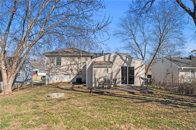 back of property with a lawn and fence