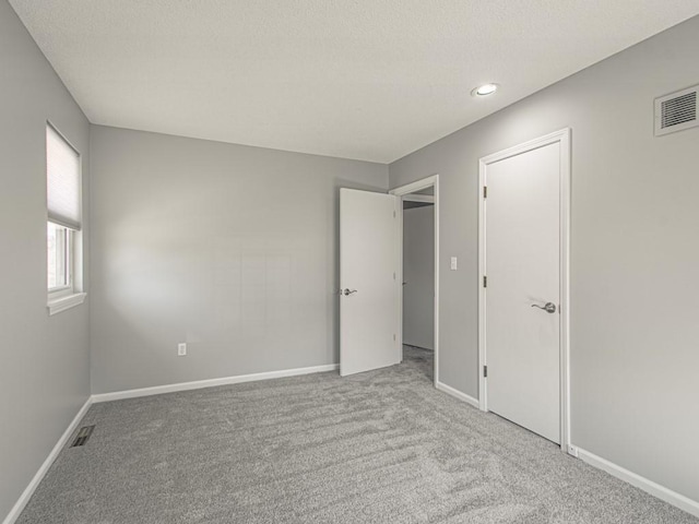 unfurnished bedroom featuring visible vents, baseboards, and carpet floors