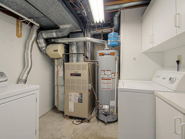 laundry area featuring water heater, heating unit, cabinet space, and washing machine and clothes dryer