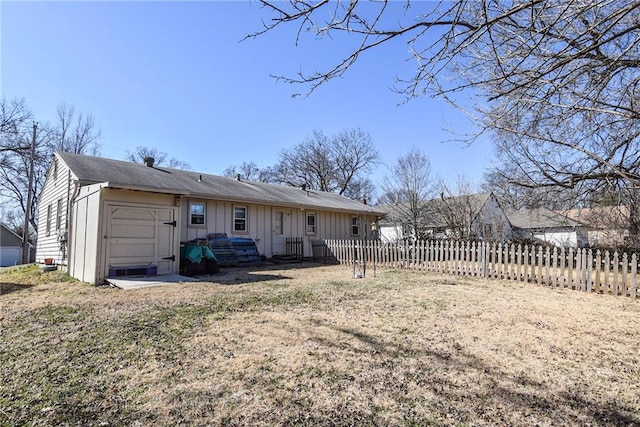 rear view of house with fence and board and batten siding