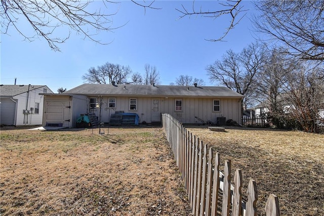 rear view of house featuring fence and board and batten siding