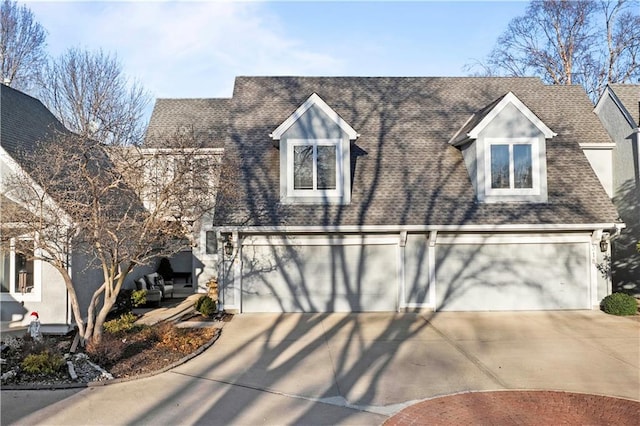 view of front of home with concrete driveway, a garage, and roof with shingles