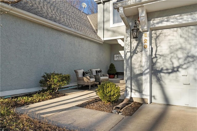 doorway to property with stucco siding and roof with shingles