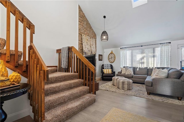 living room featuring high vaulted ceiling, stairs, and wood finished floors