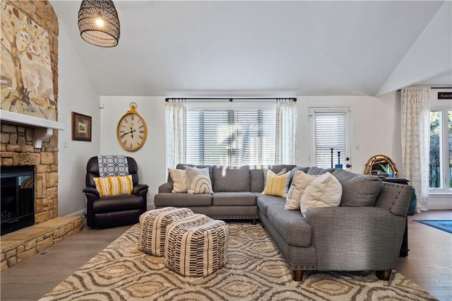 living room featuring wood finished floors, a fireplace, and high vaulted ceiling