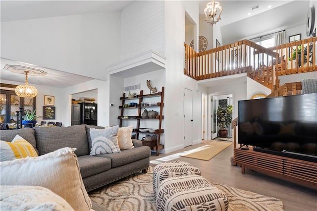 living room with a notable chandelier, visible vents, and wood finished floors