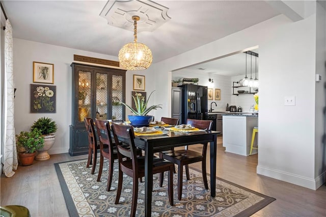 dining area with baseboards and wood finished floors