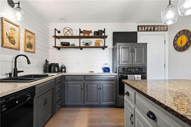 kitchen featuring black appliances, gray cabinets, a sink, open shelves, and wood finished floors