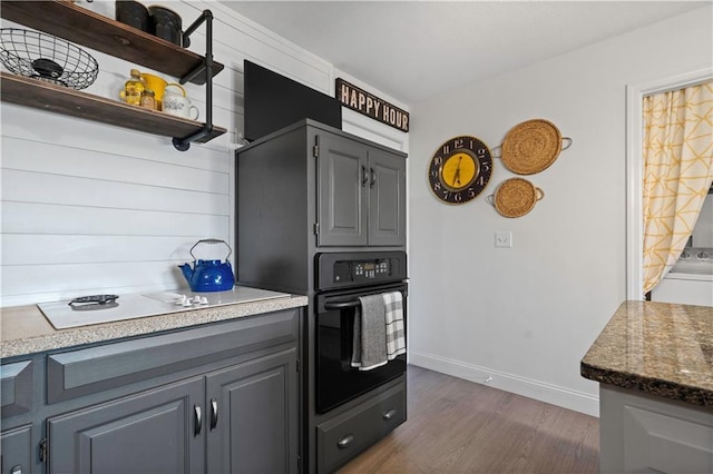 kitchen with oven, baseboards, white electric cooktop, gray cabinets, and dark wood-style floors