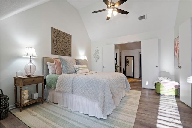 bedroom with visible vents, high vaulted ceiling, wood finished floors, and a ceiling fan