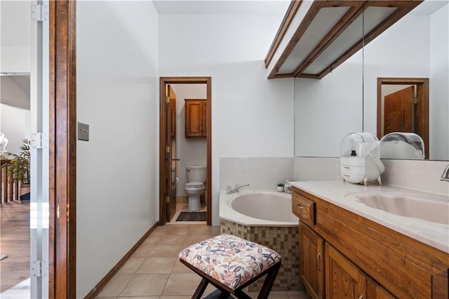 bathroom featuring tile patterned flooring, baseboards, toilet, a bath, and vanity