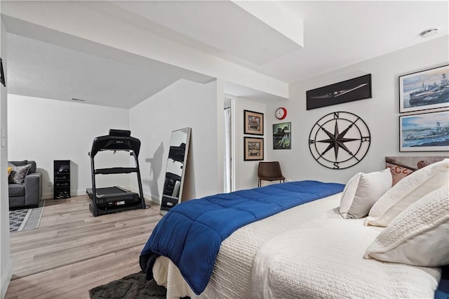 bedroom with light wood finished floors and baseboards