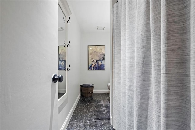 full bath featuring baseboards and toilet