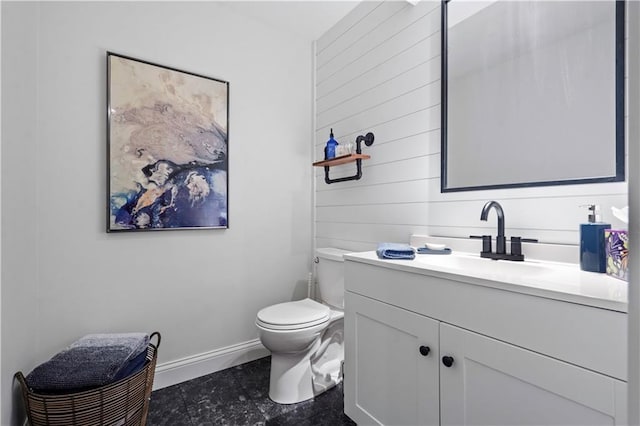 bathroom featuring baseboards, toilet, and vanity