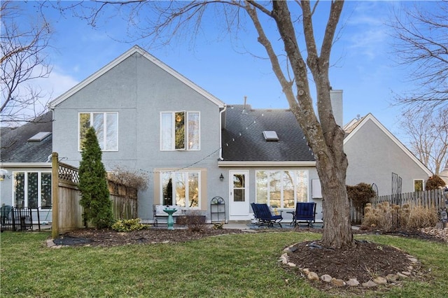 back of property featuring a patio, fence, a lawn, and stucco siding