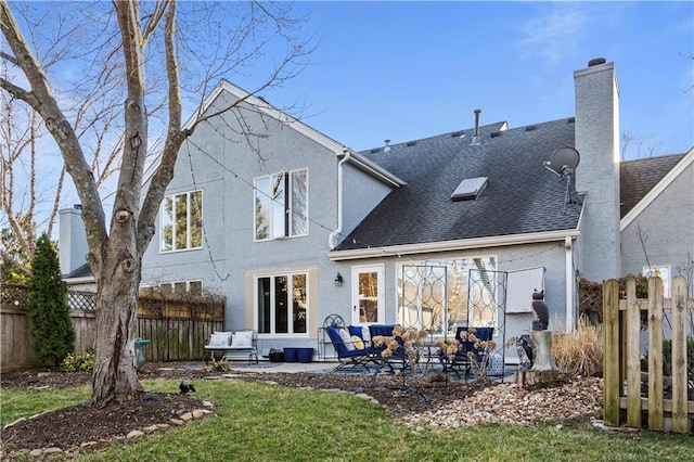 rear view of property featuring a patio, roof with shingles, a chimney, and fence