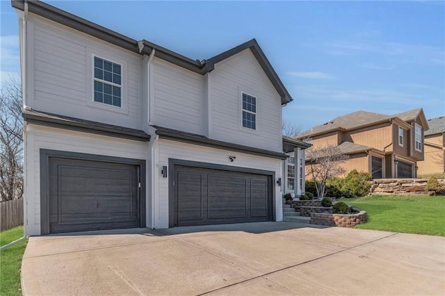 view of front of house featuring a front yard, concrete driveway, and an attached garage