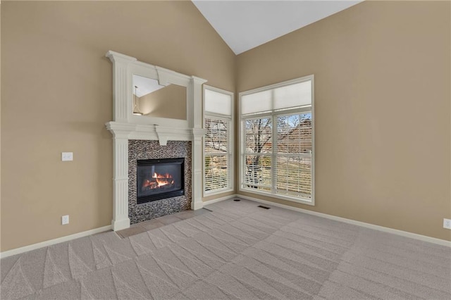 unfurnished living room with visible vents, baseboards, high vaulted ceiling, a fireplace, and light colored carpet