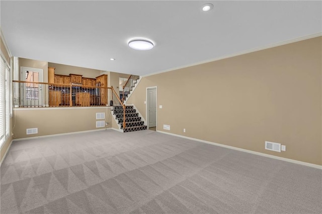 spare room featuring stairs, visible vents, baseboards, and ornamental molding