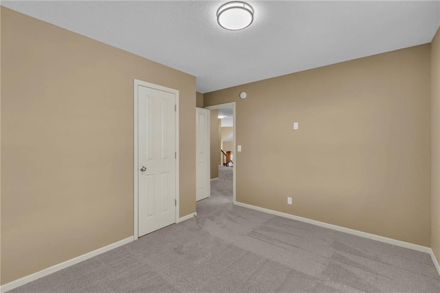 empty room featuring baseboards, carpet, and a textured ceiling