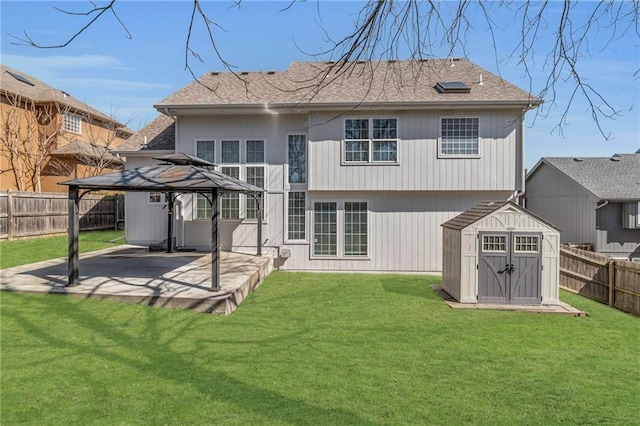 back of house featuring a storage unit, an outbuilding, a patio, a fenced backyard, and a gazebo