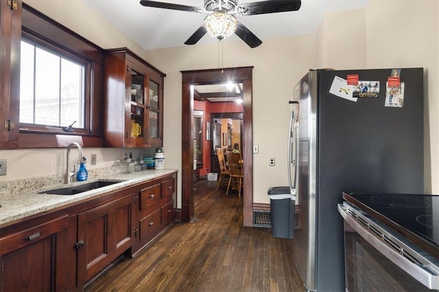 209 High St, Platte City, MO 64079 - kitchen with a sink, dark wood-style floors, glass insert cabinets, light stone countertops, and ceiling fan