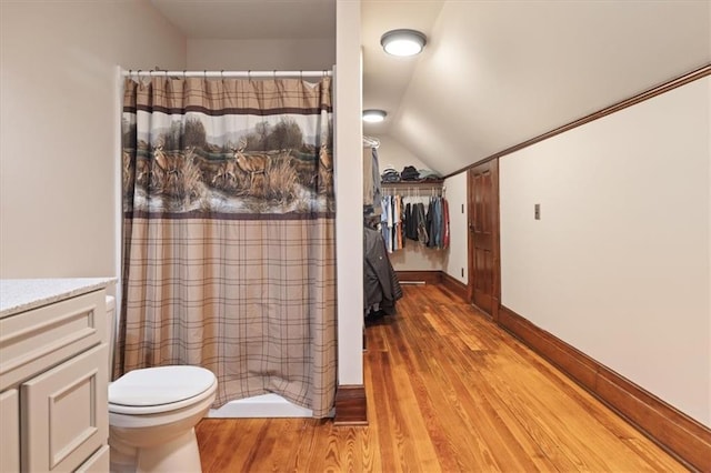 209 High St, Platte City, MO 64079 - full bathroom with toilet, lofted ceiling, wood finished floors, a shower with shower curtain, and baseboards