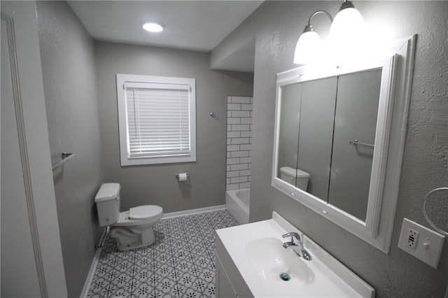 bathroom with toilet, vanity, and baseboards