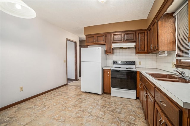 kitchen with freestanding refrigerator, a sink, decorative backsplash, range with electric cooktop, and under cabinet range hood