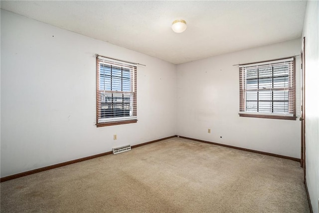 unfurnished room with visible vents, carpet floors, and baseboards