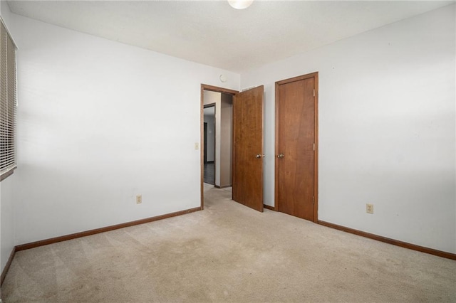 carpeted empty room featuring baseboards