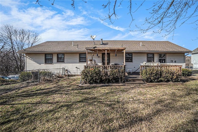 back of house featuring a yard, roof with shingles, a wooden deck, and fence