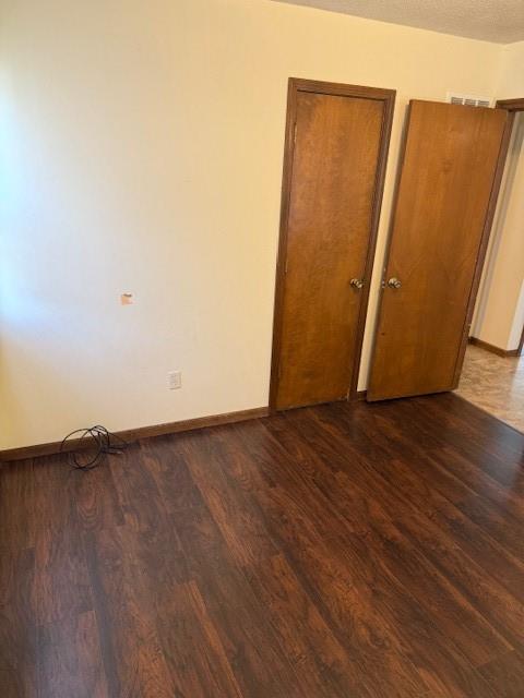 1507 W Concord Dr, Plattsburg, MO 64477 - empty room featuring dark wood-type flooring, baseboards, and a textured ceiling