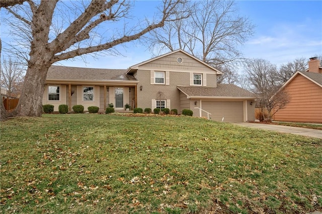 tri-level home with brick siding, a front yard, and driveway