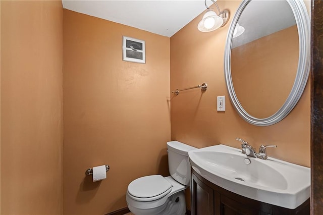 half bath featuring visible vents, toilet, and vanity