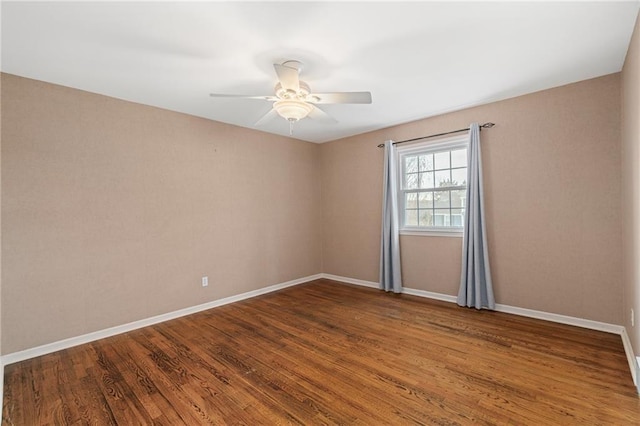 spare room with ceiling fan, baseboards, and wood finished floors