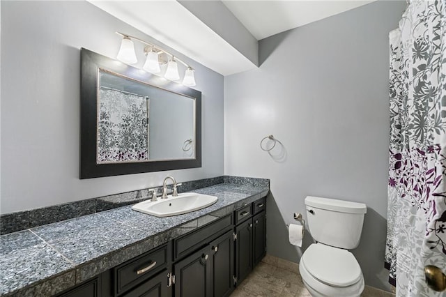 bathroom featuring toilet, vanity, and baseboards