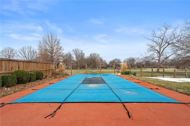 view of swimming pool featuring fence