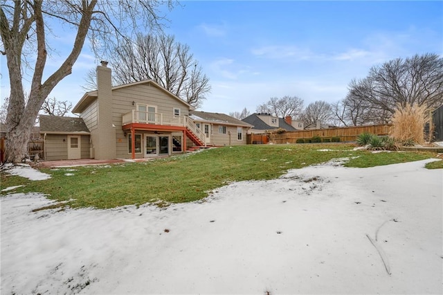 back of house with a patio area, a yard, fence, and a chimney