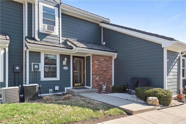 view of front of property featuring brick siding and central AC unit