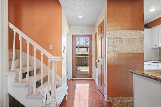 entrance foyer featuring stairway, recessed lighting, wood finished floors, and a textured ceiling