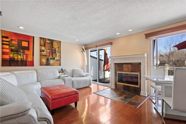 living room with recessed lighting, a textured ceiling, wood finished floors, and a fireplace