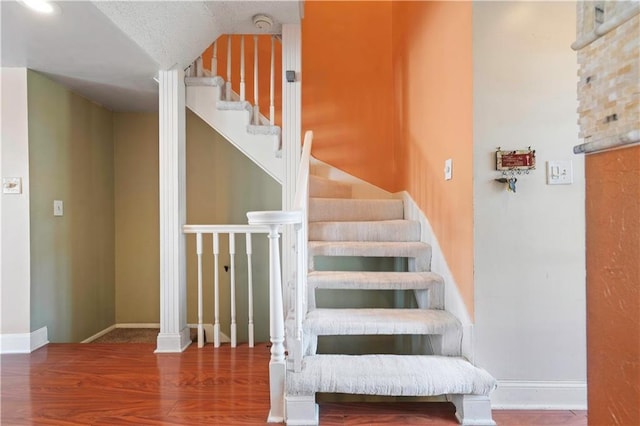 stairs with wood finished floors and baseboards