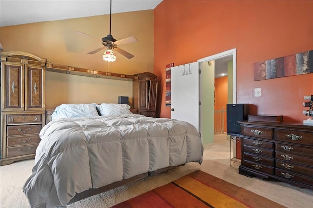 bedroom with ceiling fan, high vaulted ceiling, and light carpet