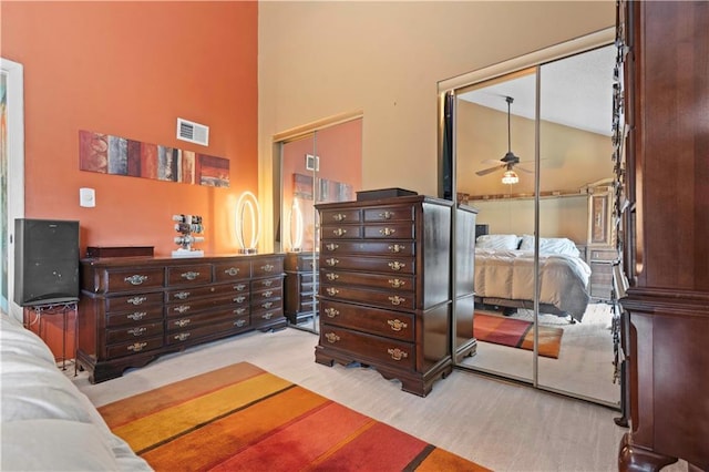 bedroom with carpet, visible vents, and high vaulted ceiling