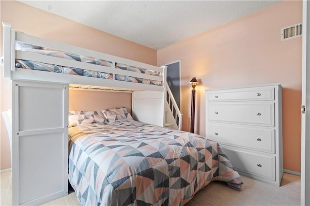 carpeted bedroom with visible vents and a textured ceiling