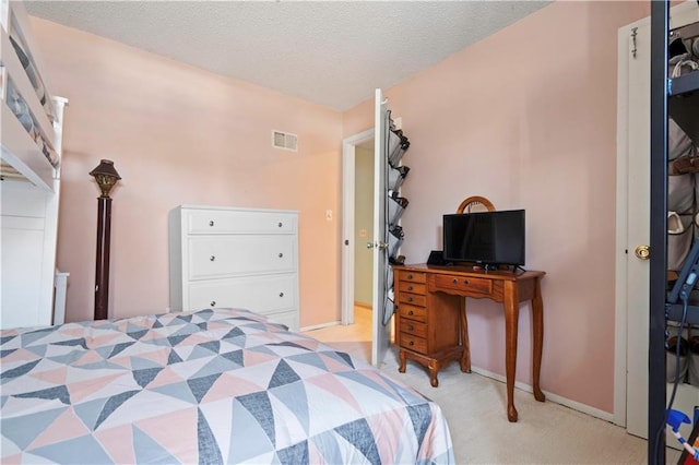 bedroom featuring visible vents, a textured ceiling, baseboards, and carpet floors