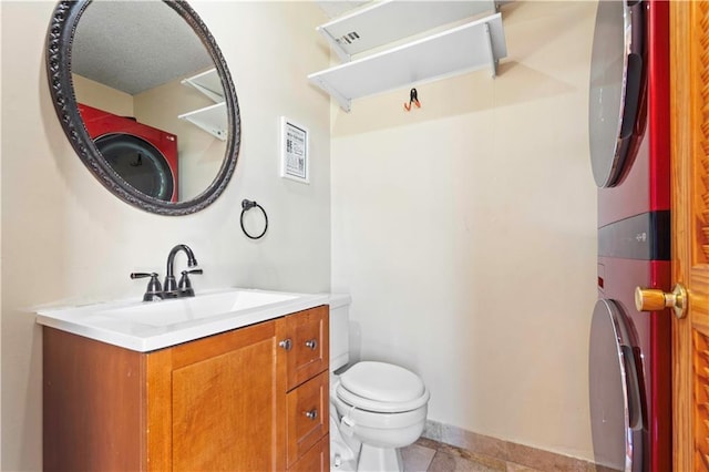 half bathroom with vanity, toilet, and baseboards