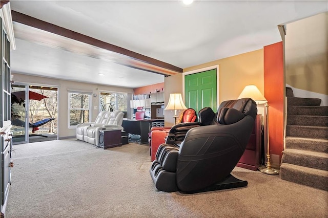 carpeted living room with stairway and beamed ceiling