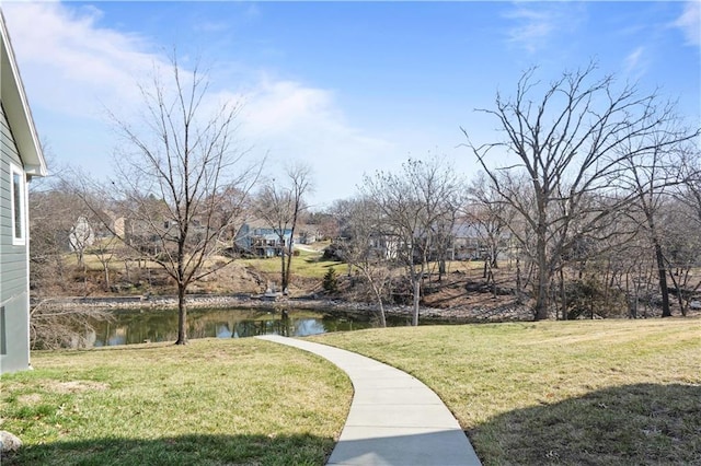 surrounding community with a yard and a water view